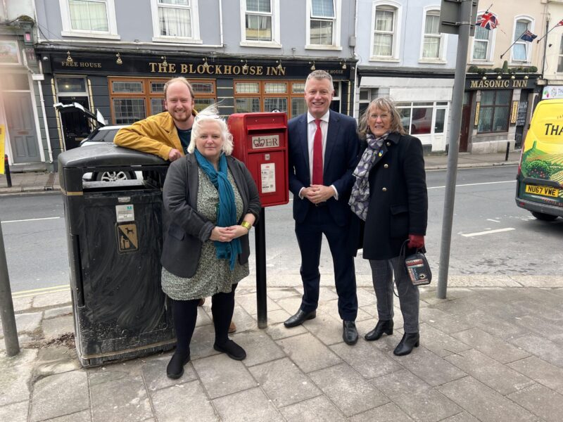 Luke stands with councillors Jemima Laing, Tom Briars-Delve and Sally Cresswell alongside the reinstalled post box in Stoke. 